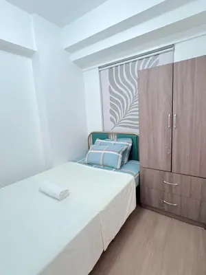 a small bedroom with a bed and a cabinet at Place to stay in pasay near Airport in Manila