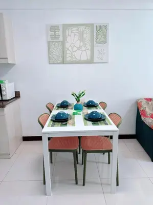 a white table with chairs and blue dishes on it at Place to stay in pasay near Airport in Manila
