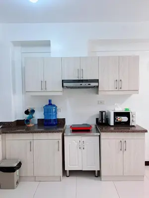 a kitchen with white cabinets and a microwave at Place to stay in pasay near Airport in Manila