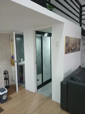 a living room with a black couch and glass doors at Stayover Transient House in Carmen