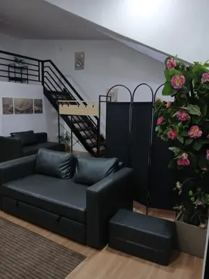 a living room with a couch and a staircase at Stayover Transient House in Carmen