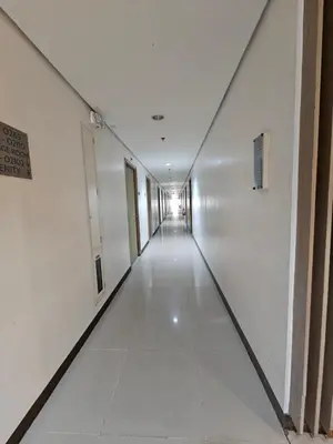 an empty hallway in a building with white walls at Shore Residences Sm Mall of Asia Caitlin in Manila