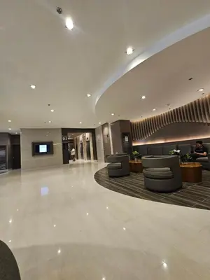a lobby with couches and a tv in a building at Shore Residences Sm Mall of Asia Caitlin in Manila