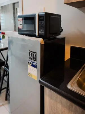 a microwave on top of a refrigerator in a kitchen at The Bat Cave 3 at Coast Residences Pasay in Manila