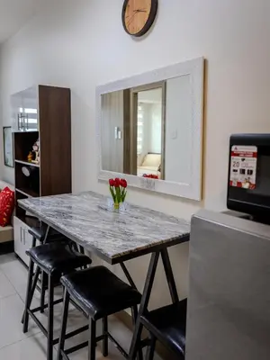 a kitchen with a table with chairs and a mirror at The Bat Cave 3 at Coast Residences Pasay in Manila