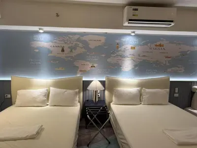 two beds in a room with a map of the world at Modern Boutique Spacious Apartment Near Airport OKADA SOLAIRE MOA in Manila