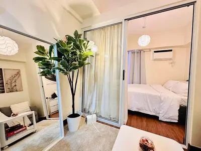 a bedroom with a bed and a large mirror at Prisma Residences by Kozy Mood near BGC in Manila