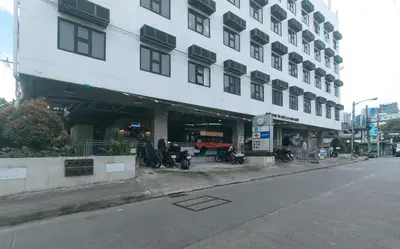 a large white building with motorcycles parked in front of it at RedDoorz Premium at MyTown New York in Manila