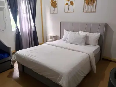 a bed with white sheets and pillows in a bedroom at HOPE RESIDENCES UNIT 606 building D in Trece Martires