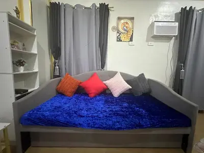 a bed with colorful pillows on it in a room at HOPE RESIDENCES UNIT 606 building D in Trece Martires