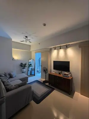 a living room with a couch and a flat screen tv at 6G Manor in Manila