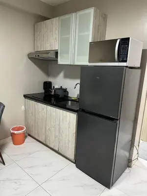 a kitchen with a black refrigerator and a microwave at Monarch Parksuites staycation near Moa IKEA Solaire in Manila