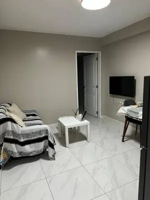 a white living room with a bed and a tv at Monarch Parksuites staycation near Moa IKEA Solaire in Manila