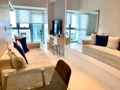 a living room with a couch and a table at Uptown Parksuites Posh Modern Minimalist in Manila