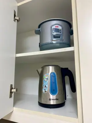 a slow cooker sitting inside of a kitchen cabinet at Uptown Parksuites Posh Modern Minimalist in Manila