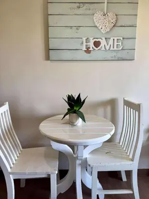 a white table with two chairs and a potted plant at The Cozy Rustic in General Trias