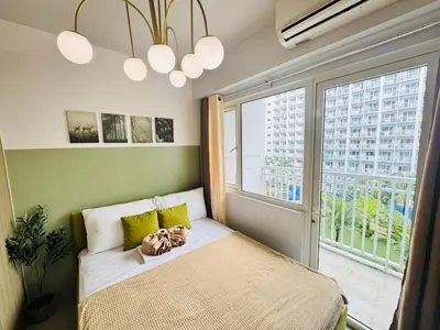 a bedroom with a bed and a large window at Shore Residences 2 Beds Forest Green RM 630 by Prime Stay in Manila