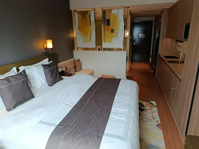 a large white bed in a hotel room at RBR LUX at Novotel Manila Hotel Residences Acqua in Manila