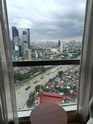 a view of a city from a window at RBR LUX at Novotel Manila Hotel Residences Acqua in Manila