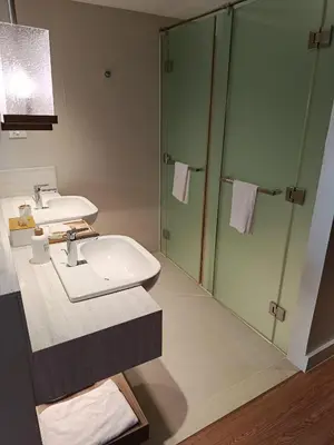a bathroom with a sink and a shower at RBR LUX at Novotel Manila Hotel Residences Acqua in Manila