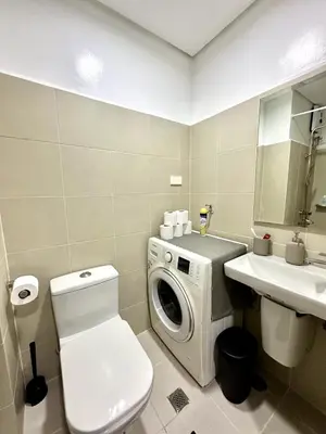 a bathroom with a washing machine next to a sink at City SkyView - Level 24 - Pool - Lush Residences in Manila