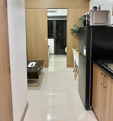 a kitchen with a black refrigerator and a table at City SkyView - Level 24 - Pool - Lush Residences in Manila
