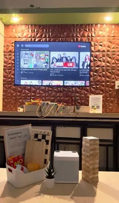 a restaurant counter with a large monitor on a wall at 1BR Unit for 2 pax Makati City in Manila