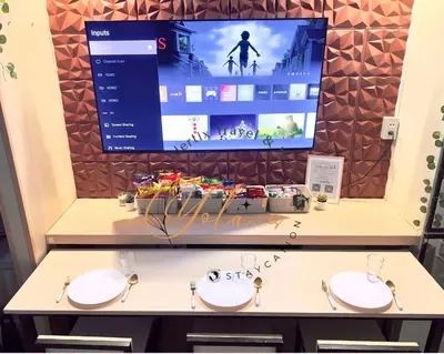 a tv screen above two sinks in a room at 1BR Unit for 2 pax Makati City in Manila