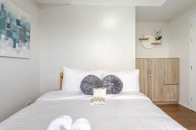a bedroom with a bed with white sheets and pillows at Air Bel & Be! Your space, Your calm, Your comfort in Manila