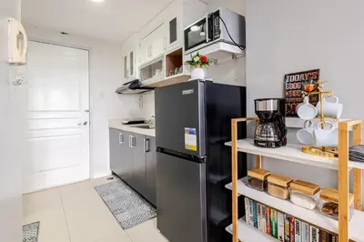 a kitchen with a black refrigerator and a shelf with books at Air Bel & Be! Your space, Your calm, Your comfort in Manila