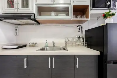a kitchen with white cabinets and a sink at Air Bel & Be! Your space, Your calm, Your comfort in Manila