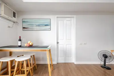 a kitchen with a table and stools in a room at Air Bel & Be! Your space, Your calm, Your comfort in Manila