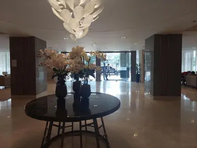a table with vases of flowers on it in a lobby at StaycationPH in Manila