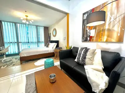 a living room with a couch and a bed at 1BR - Uptown BGC Taguig in Manila