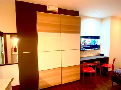 a living room with a large cabinet with a television at Opulent Condo Knightsbridge Residences in Manila