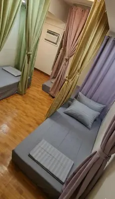 a bedroom with two beds with curtains at Thai Nee Homestay in Manila