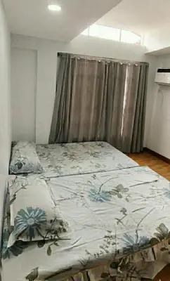a bed in a bedroom next to a window at Thai Nee Homestay in Manila