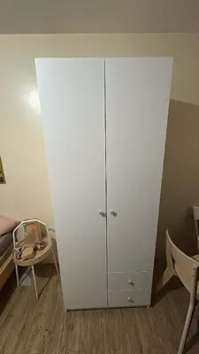 a white cabinet in the corner of a bedroom at ANANDA SQUARE studio unit in Manila