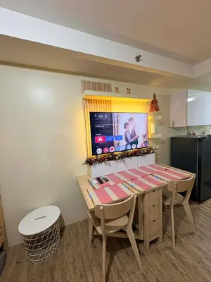 a dining room with a table and a television at ANANDA SQUARE studio unit in Manila