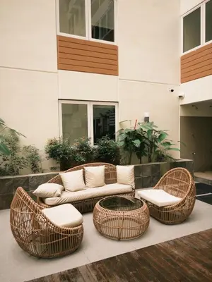 three wicker chairs and a couch on a patio at ANANDA SQUARE studio unit in Manila