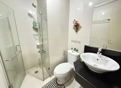 a bathroom with a toilet and a sink and a shower at Condo in Pasay Across Airport NAIA Terminal 3 Pool View in Manila