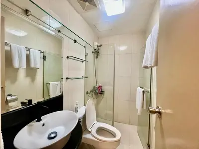 a bathroom with a sink and a toilet and a shower at Casa Ysabella at Stamford, Mckinley Hill in Manila