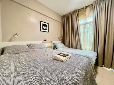 a bedroom with two beds and a window at Casa Ysabella at Stamford, Mckinley Hill in Manila