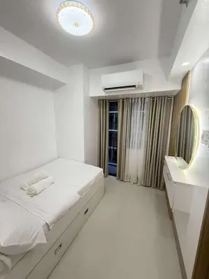 a white bedroom with a bed and a mirror at Condo in Shore 3 Residences, Pasay in Manila