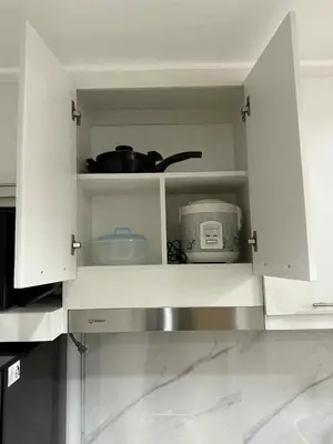 a kitchen with white cabinets with a toaster and a appliance at Condo in Shore 3 Residences, Pasay in Manila
