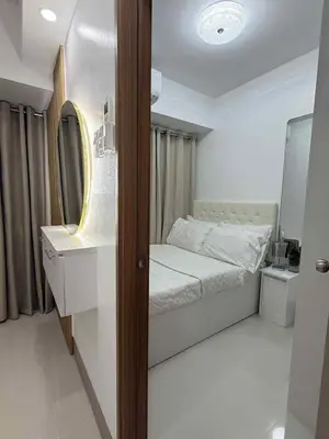a small bedroom with a bed and a mirror at Condo in Shore 3 Residences, Pasay in Manila