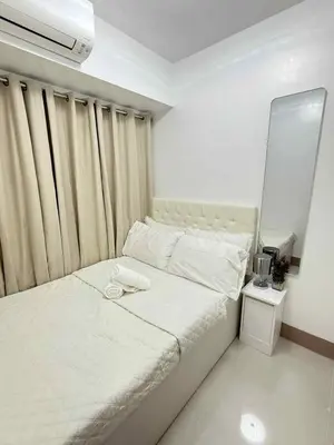 a bedroom with a white bed with a mirror at Condo in Shore 3 Residences, Pasay in Manila