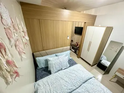 a small bedroom with a bed and a mirror at Shell Residence MOA Pasay by Kathy in Manila
