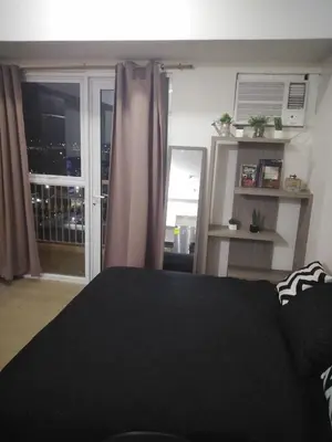 a bedroom with a black bed and a window at Venice Mall Area Mckinley Hills Taguig in Manila