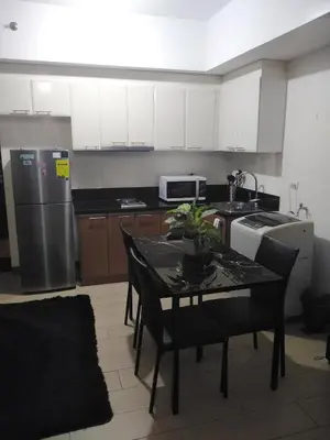 a small kitchen with a table and a refrigerator at Venice Mall Area Mckinley Hills Taguig in Manila